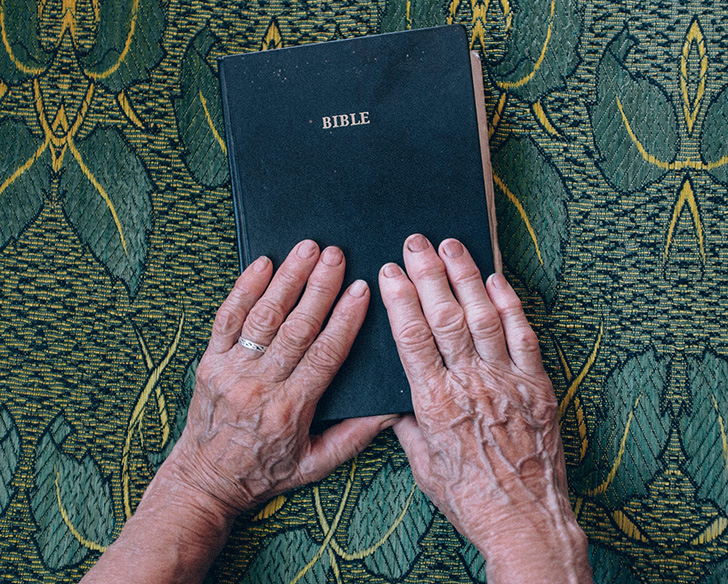 old woman's hands and bible